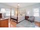 Main bedroom featuring hardwood floors, a four poster bed, and plenty of natural light at 14232 Kendalton Meadow Dr, Mint Hill, NC 28227