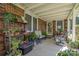 Covered porch area with brick and tile, featuring seating and many decorative plants at 1610 Union Rd # 1610B, Gastonia, NC 28054