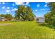Spacious backyard with a storage shed and green grass under a partly cloudy blue sky at 189 Lochshire Ln, Woodleaf, NC 27054