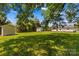Spacious backyard with a green grass, storage sheds and surrounded by trees at 189 Lochshire Ln, Woodleaf, NC 27054