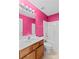 Bright bathroom featuring modern vanity, toilet and shower-tub combo with pink walls at 189 Lochshire Ln, Woodleaf, NC 27054
