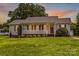 Charming single-story home features a welcoming front porch and a well-manicured lawn at 189 Lochshire Ln, Woodleaf, NC 27054