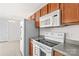 Efficient kitchen includes white appliances, wood cabinets, and granite counters at 189 Lochshire Ln, Woodleaf, NC 27054