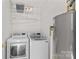 Laundry room featuring washer, dryer, water heater, and shelving at 189 Lochshire Ln, Woodleaf, NC 27054
