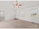 Open living room with neutral carpet, a ceiling fan, and access to additional rooms at 189 Lochshire Ln, Woodleaf, NC 27054