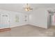 Bright living room features neutral carpet, a ceiling fan, and ample natural light at 189 Lochshire Ln, Woodleaf, NC 27054