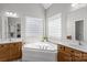 Bright bathroom features a soaking tub with glass block windows and double sink vanity at 2019 Lynmore Dr, Sherrills Ford, NC 28673