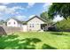 View of the back of the home with a well-maintained lawn and privacy fence on a sunny day at 232 Orange St, Charlotte, NC 28205