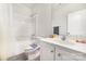 Bathroom featuring a shower over tub with white subway tile, white vanity, and gray flooring at 232 Orange St, Charlotte, NC 28205