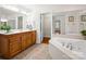 This bathroom has a dual sink vanity, tub, a closet with shelves, and a large mirror for added convenience at 2872 Wheat Field Ct, Lincolnton, NC 28092