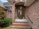 Elegant brick entryway with a classic wooden front door and decorative plants at 2872 Wheat Field Ct, Lincolnton, NC 28092