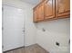 Spacious laundry room featuring tile floor, wooden cabinets, and a white door at 2872 Wheat Field Ct, Lincolnton, NC 28092