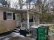 Rear view of home featuring a covered porch and exterior access with bins, showing space and functionality at 2942 Reid Ave, Charlotte, NC 28208