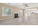 Spacious living room with a fireplace, modern ceiling fan, and abundant natural light at 3043 Streamlet Way, Monroe, NC 28110