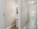 Hallway powder room with pedestal sink and neutral color palette at 3043 Streamlet Way, Monroe, NC 28110