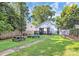 Backyard featuring a fire pit, picnic table, shed, and lush greenery at 323 Keswick Ave, Charlotte, NC 28206