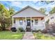 Charming home featuring a cozy front porch with ceiling fan and a beautifully landscaped yard at 323 Keswick Ave, Charlotte, NC 28206
