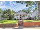Charming home with a covered front porch, manicured lawn, and brick retaining wall at 323 Keswick Ave, Charlotte, NC 28206