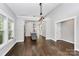 Spacious room with hardwood floors leading to kitchen with a kitchen island and modern lighting fixtures at 323 Keswick Ave, Charlotte, NC 28206