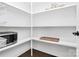 Well-organized pantry with ample white shelving and a microwave for convenient food storage and preparation at 323 Keswick Ave, Charlotte, NC 28206