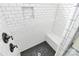 Elegant tiled shower featuring river rock flooring, white tile surround and bronze shower fixtures at 323 Keswick Ave, Charlotte, NC 28206