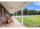 Inviting front porch featuring rocking chairs, decorative pillows, and a serene view of the lush front yard at 3451 Greene Rd, Monroe, NC 28110