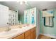 Bright bathroom featuring double sinks, light wood cabinets, beach themed decor and a shower with patterned curtain at 3451 Greene Rd, Monroe, NC 28110