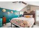 Charming bedroom with vaulted ceilings, a large bed with colorful patterned bedding, and teal accent wall at 3451 Greene Rd, Monroe, NC 28110
