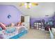 Purple bedroom boasting a doll house and white trim, and a window overlooking the backyard at 3451 Greene Rd, Monroe, NC 28110