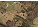 Expansive property featuring a home, pond, outbuildings, and natural surroundings, as seen from an aerial view at 3451 Greene Rd, Monroe, NC 28110