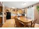 Eat-in kitchen boasts wood cabinets, black appliances, and adjacent dining area at 3451 Greene Rd, Monroe, NC 28110