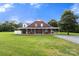 Beautiful brick home with a sprawling front yard, covered porch, and classic architectural details, perfect for Gathering living at 3451 Greene Rd, Monroe, NC 28110