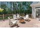 Charming backyard deck with cozy seating, a fire pit, and string lights amidst a lush, wooded setting at 347 Bayberry Creek Cir, Mooresville, NC 28117