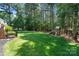 Lush backyard with mature trees, a playset, and plenty of green space for outdoor activities and enjoyment at 347 Bayberry Creek Cir, Mooresville, NC 28117