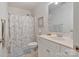 Cozy bathroom with white vanity, framed floral wall art, and shower with blue floral curtain at 347 Bayberry Creek Cir, Mooresville, NC 28117