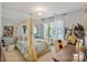 Light-filled bedroom features a charming canopy bed with fairy lights and a cozy study area by the window at 347 Bayberry Creek Cir, Mooresville, NC 28117