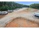 View of RV and boat storage amenities, featuring a fenced in area, graveled ground, and surrounding trees at 347 Bayberry Creek Cir, Mooresville, NC 28117