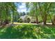 Beautiful home nestled among mature trees, with green lawn, and inviting walkway to the front door at 347 Bayberry Creek Cir, Mooresville, NC 28117