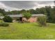 Brick home with an attached carport and partially landscaped yard on a large grassy lot with mature trees at 356 Lucky Hollow Rd, Hickory, NC 28601