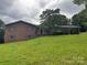 Brick home with gray shutters and a carport features mature trees, a front porch, and a large, grassy yard at 356 Lucky Hollow Rd, Hickory, NC 28601