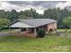 Brick home with an attached carport and large grassy yard, nestled amongst mature trees for a private feel at 356 Lucky Hollow Rd, Hickory, NC 28601