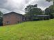 Brick home with gray shutters and a carport features mature trees, a front porch, and a sloping, grassy yard at 356 Lucky Hollow Rd, Hickory, NC 28601
