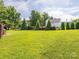 Spacious backyard featuring a large green lawn, mature trees, and landscaped garden, perfect for outdoor activities at 3697 Travertine Dr, Lancaster, SC 29720
