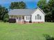 Exterior view of the home featuring a well-maintained lawn, outdoor patio, and mature landscaping at 3697 Travertine Dr, Lancaster, SC 29720