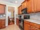 Functional kitchen with black appliances, wood cabinets, tile backsplash and view to the dining room at 3697 Travertine Dr, Lancaster, SC 29720
