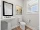 Elegant powder room with pedestal sink, modern fixtures, and decorative wall art at 416 Balboa St, Matthews, NC 28104