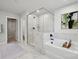 Bright bathroom features a large tub, glass shower and double sinks at 416 Balboa St, Matthews, NC 28104