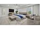 A bright, spacious primary bedroom featuring tray ceilings, a ceiling fan and a sitting area at 416 Balboa St, Matthews, NC 28104
