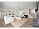 Open-concept living room with fireplace, ceiling fan, and seamless access to the modern kitchen and dining area at 416 Balboa St, Matthews, NC 28104
