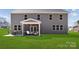Backyard view featuring a screened porch, comfortable seating, and a spacious green lawn at 416 Balboa St, Matthews, NC 28104